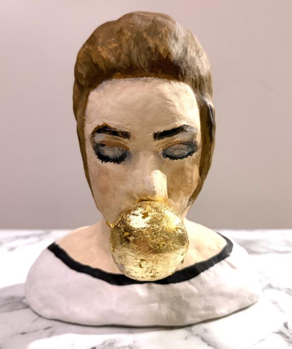 Frau, Büste braunes Haar Low bun, Kaugummiblase aus Blattgold, Shirt weiß, schwarz eingefasst